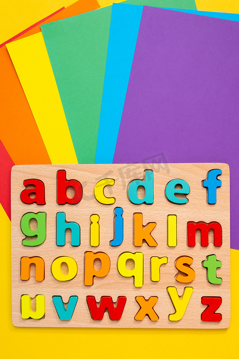 彩色背景顶视图上的英文字母。图片