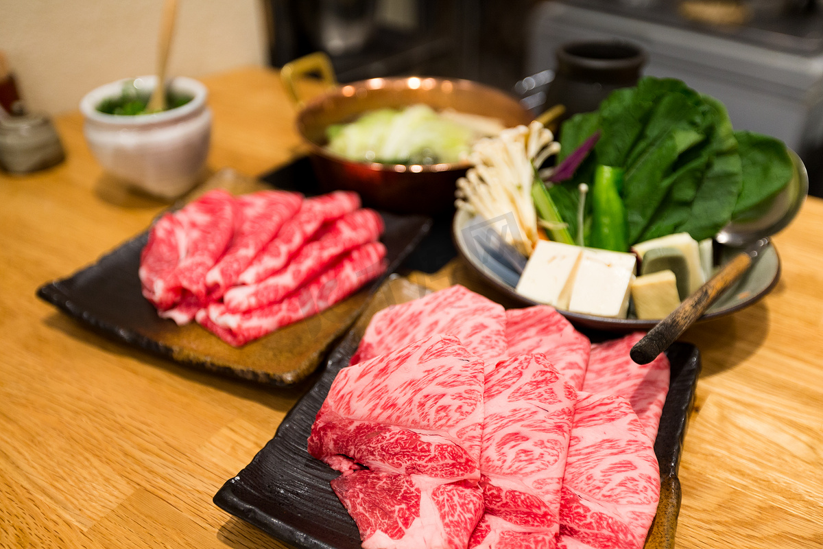 寿喜烧的新鲜牛肉、猪肉片和海鲜图片