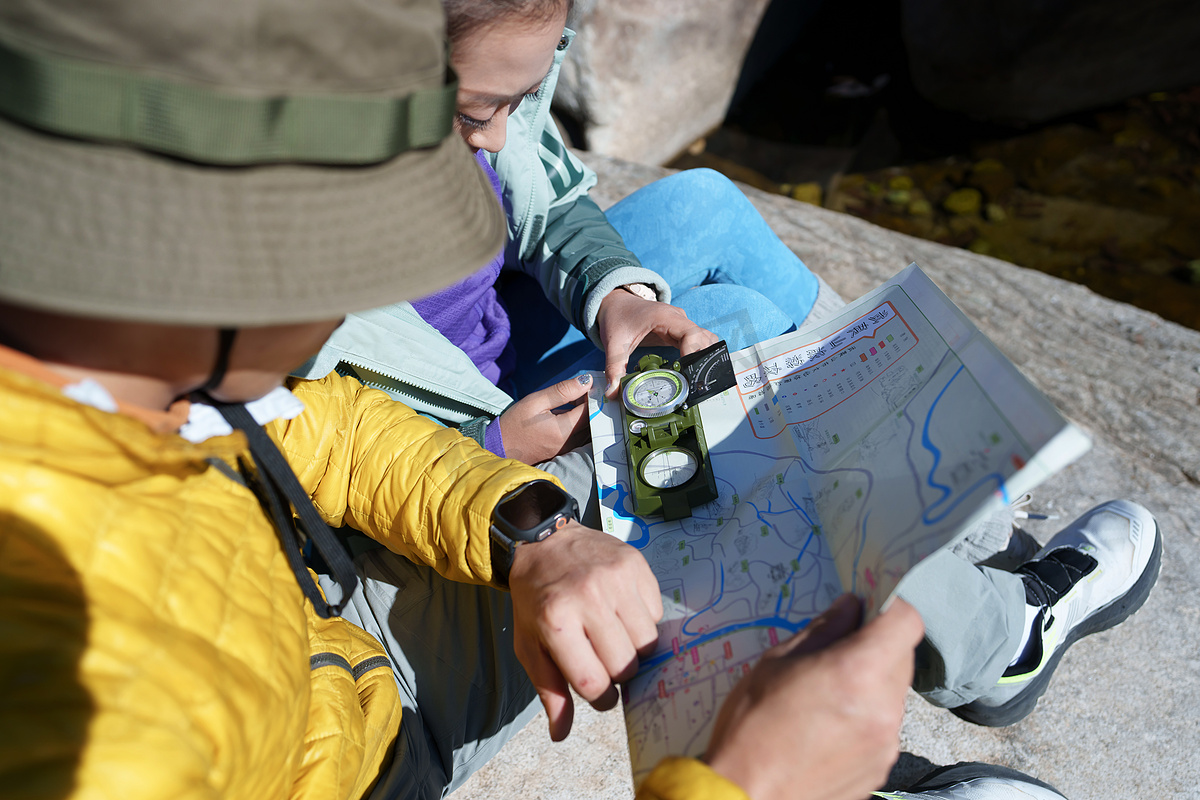 户外旅游的青年伴侣使用地图指南针图片