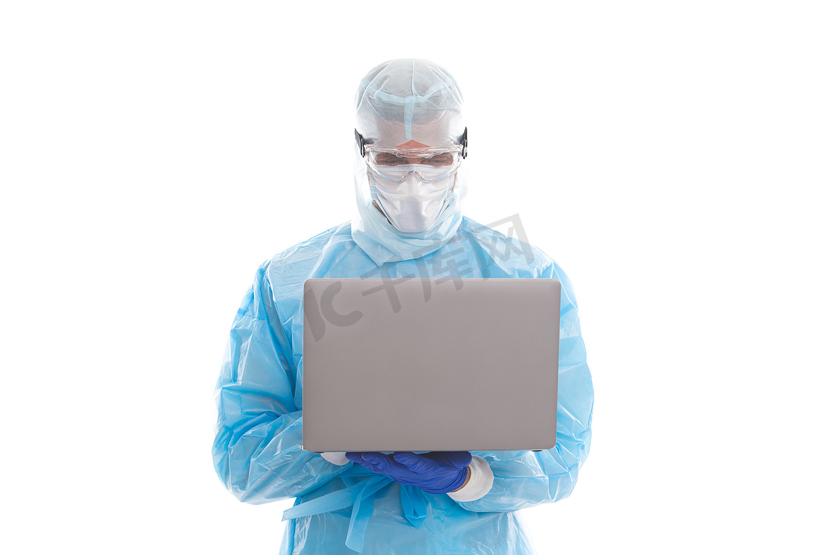 在禽流感大流行期间，男医生流行病学家戴着口罩和安全防护服，在计算机上工作，在线帮助.图片