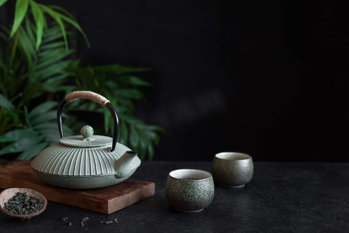 在黑色背景上的茶壶和茶杯, 复制空间。传统的亚洲安排茶道-铁茶和陶瓷茶杯与茶.图片