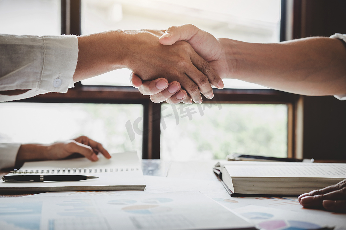 业务握手后讨论好交易成交签署协议并成为业务合作伙伴, 为两家公司签约, 成功的商人握手.图片