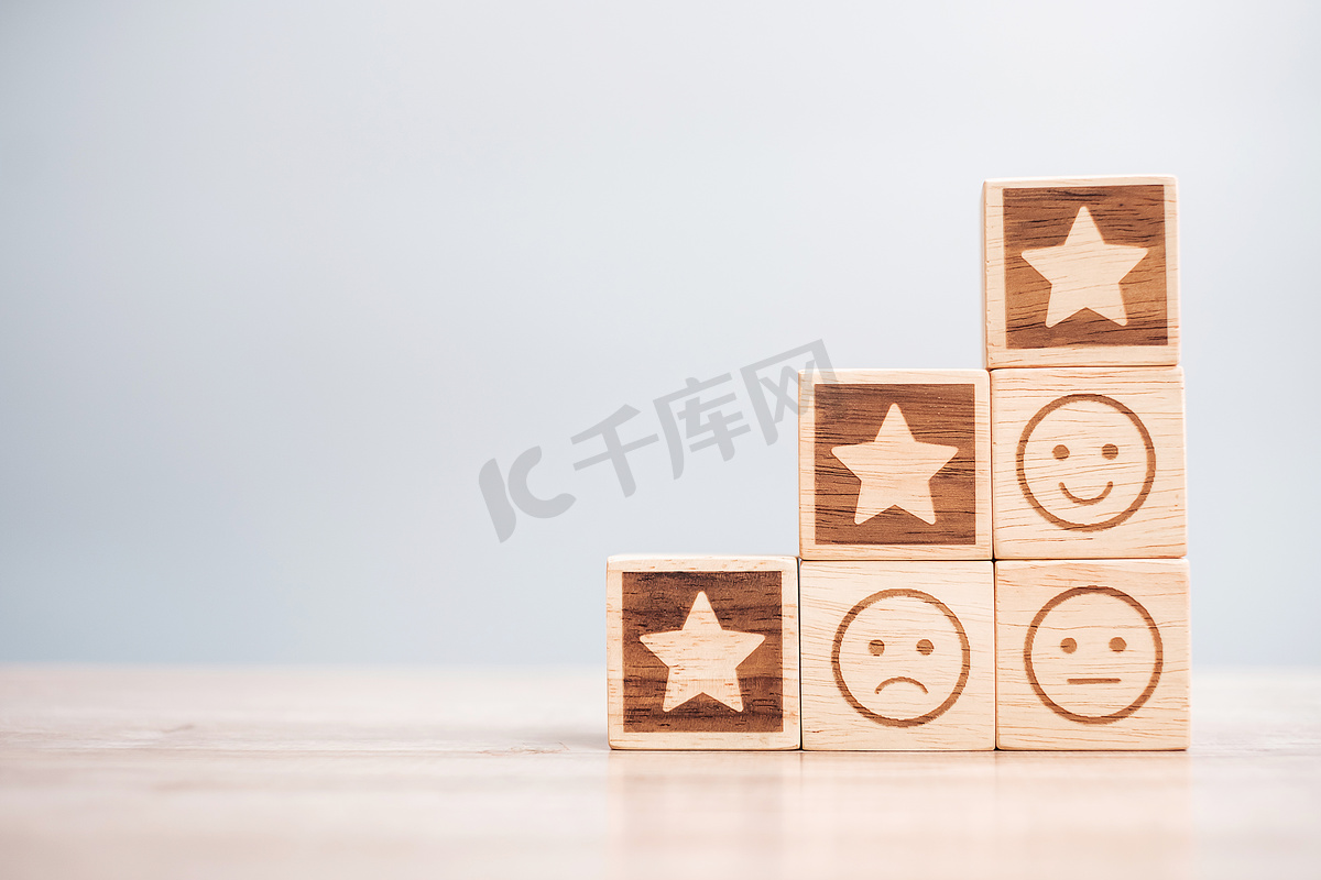 情感面和星形符号块在桌子背景上。服务评级、排名、客户审查、满意度、评价和反馈概念图片
