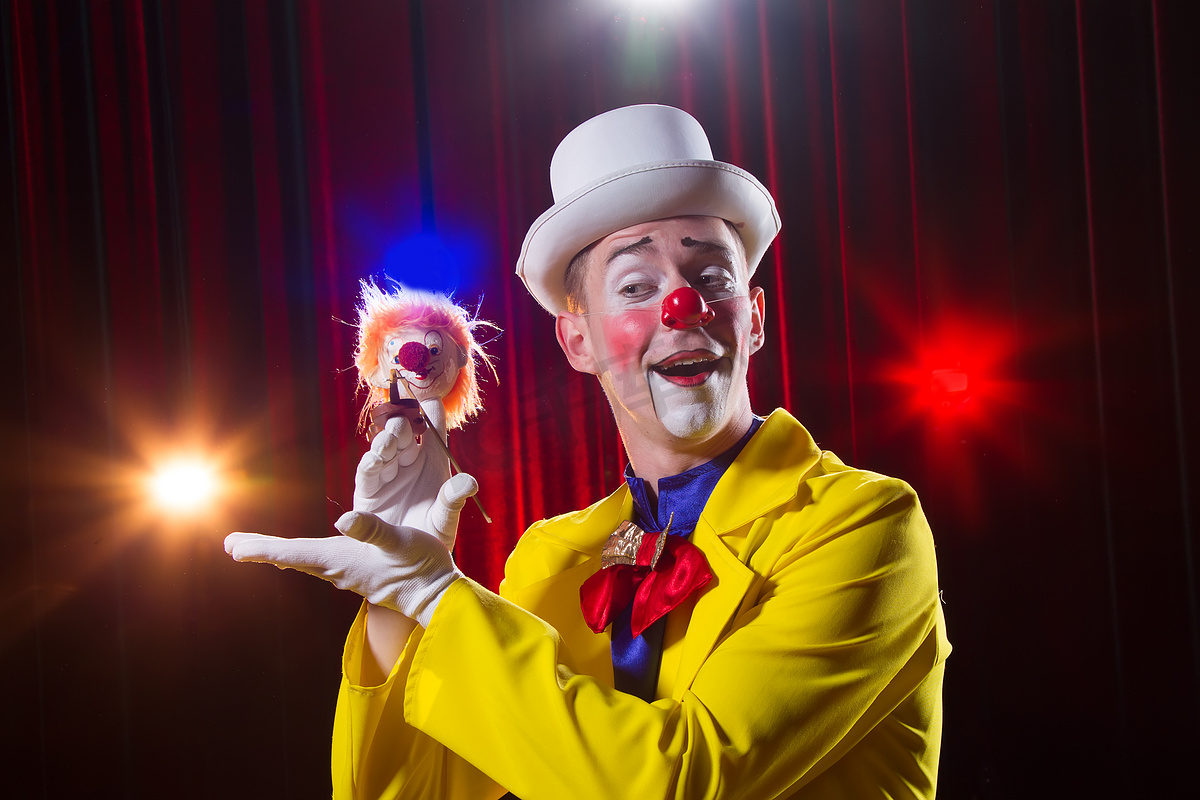 马戏团小丑表演数字。穿着小丑装的男人，有玩具图片