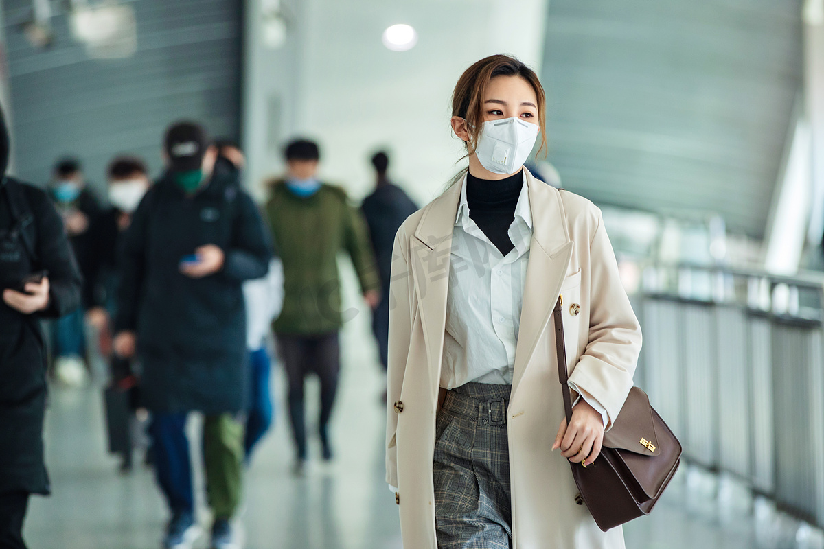 戴口罩的年轻女人走在地铁站里图片
