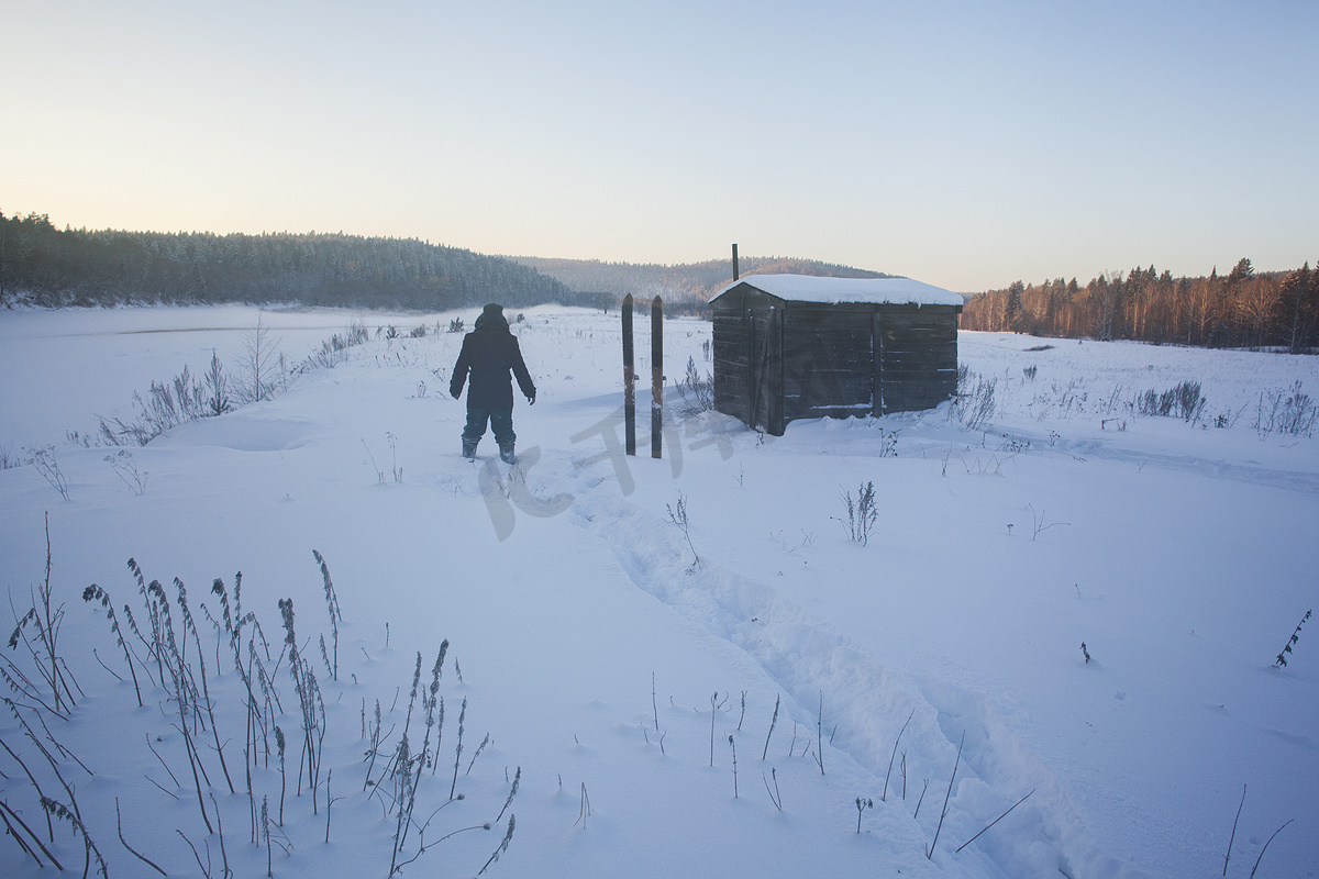 俄罗斯斯维尔德洛夫斯克的村白雪覆盖的风景中的人的背影图片
