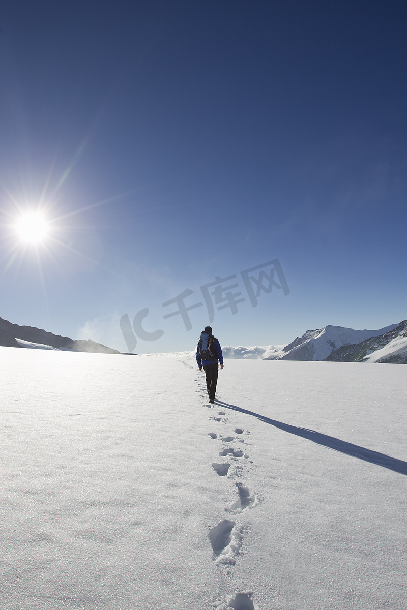 男性徒步旅行者的后景和雪地脚印瑞士格林德尔瓦尔德的图片