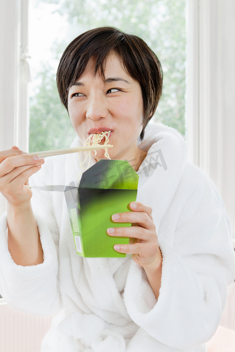 穿浴袍的女人吃中国菜图片
