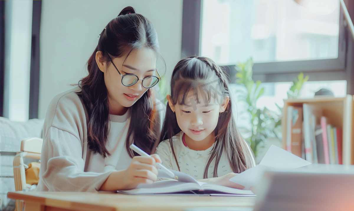 亚洲人辅导女儿做作业的青年女人图片