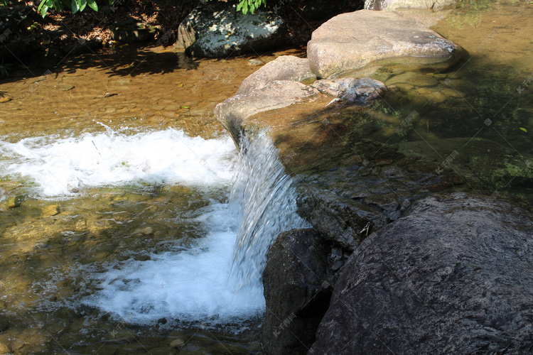 岩石上水流下激起水花自然风景摄