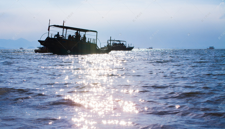 波光粼粼海水和渔船摄影图