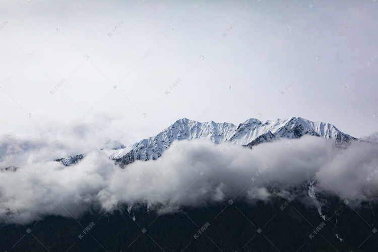 云雾环绕雪山摄影图