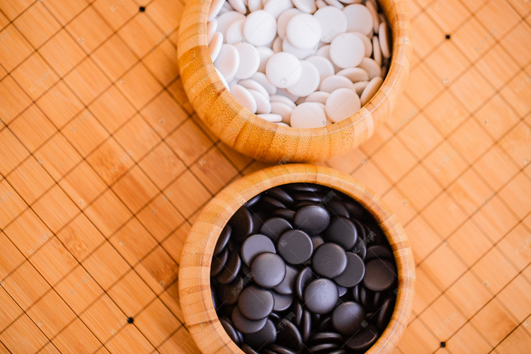 围棋棋盘上的棋罐分别装满黑白棋子高清摄影大图-千库网