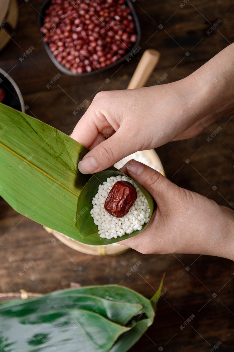 美食端午节女人的手在家里包粽子摄影图配图