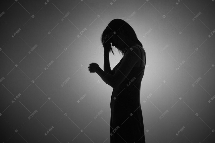 人像剪影夜晚一个女人在室内低头烦恼摄影图配图