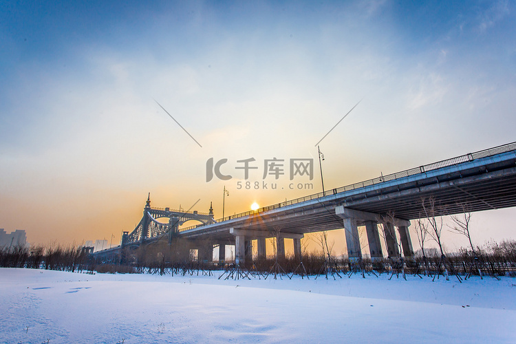 雪景夕阳大桥摄影图