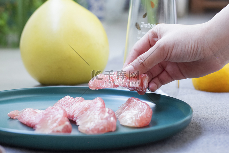 用手拿起红色血柚饱满的果肉