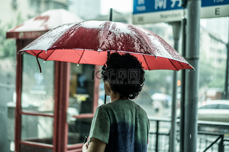 上海下雨天街道打伞的老人