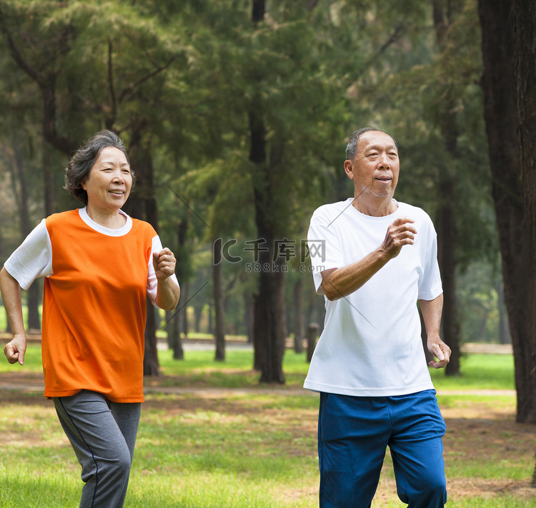 快乐的年长夫妇一起在公园里慢跑