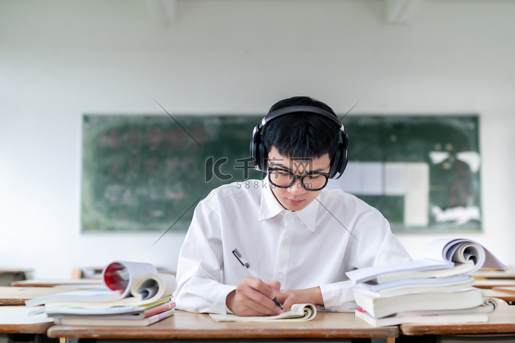 课室里听音乐刷题的男学生