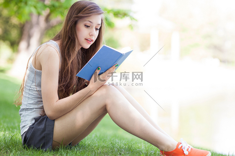 年轻女子读本书户外