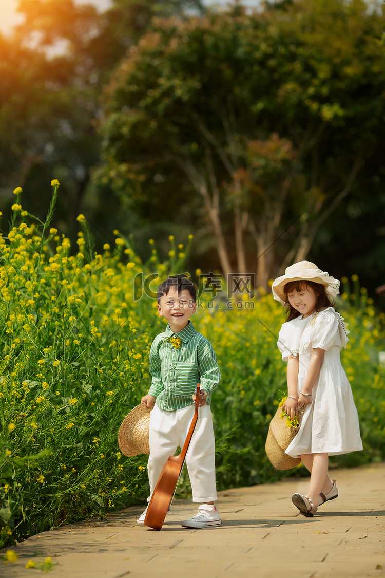 温馨的两个孩子在油菜花田游玩摄