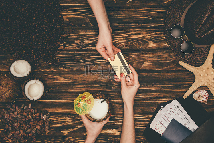 女性在木质表面用信用卡支付椰子