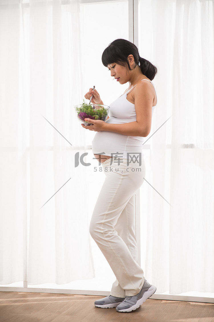 幸福的孕妇吃蔬菜沙拉