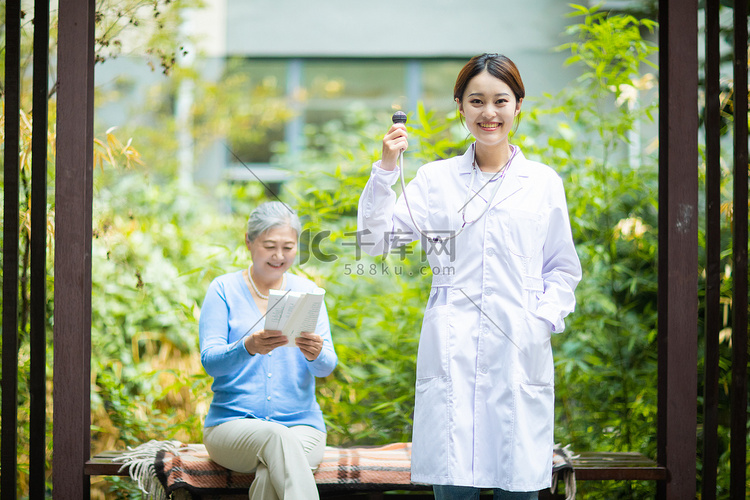 老年健康白天女医生户外举着听诊