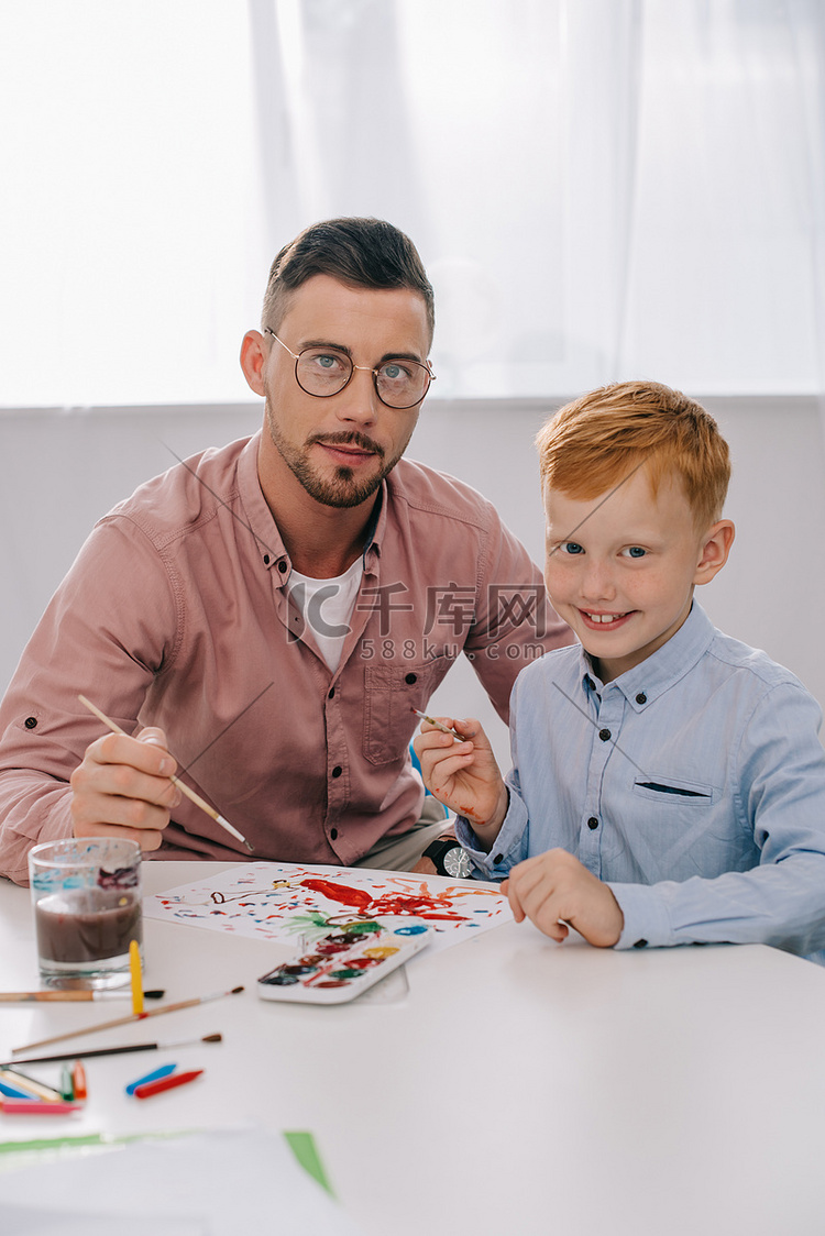 老师和小男孩的画像坐在桌上的油