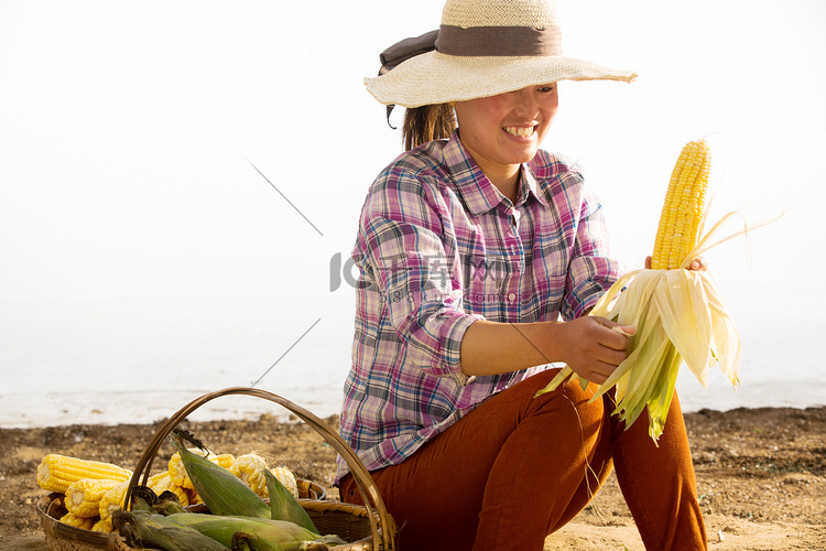 中年女人拿着玉米