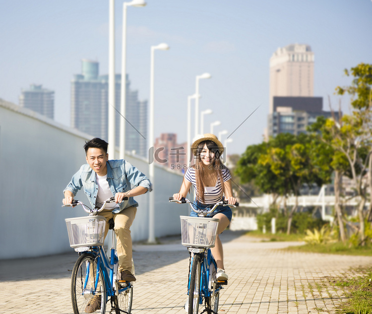 快乐的年轻夫妇，骑着自行车在城