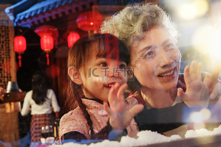 小女孩和祖母看向窗外