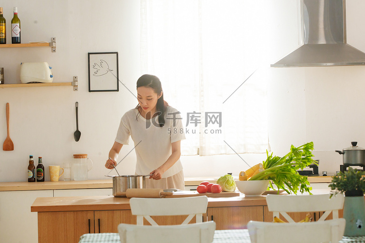 青年女人在厨房里做饭