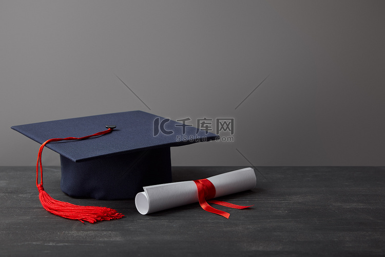 文凭和学术盖帽与红色流苏在黑暗
