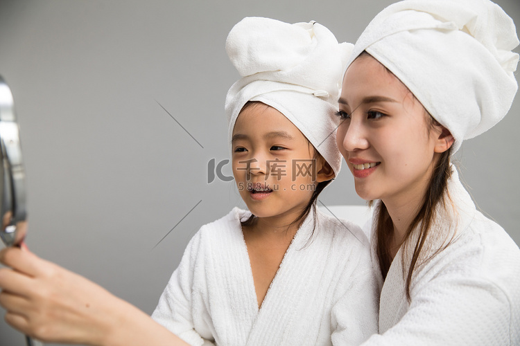 穿着浴袍的母女照镜子