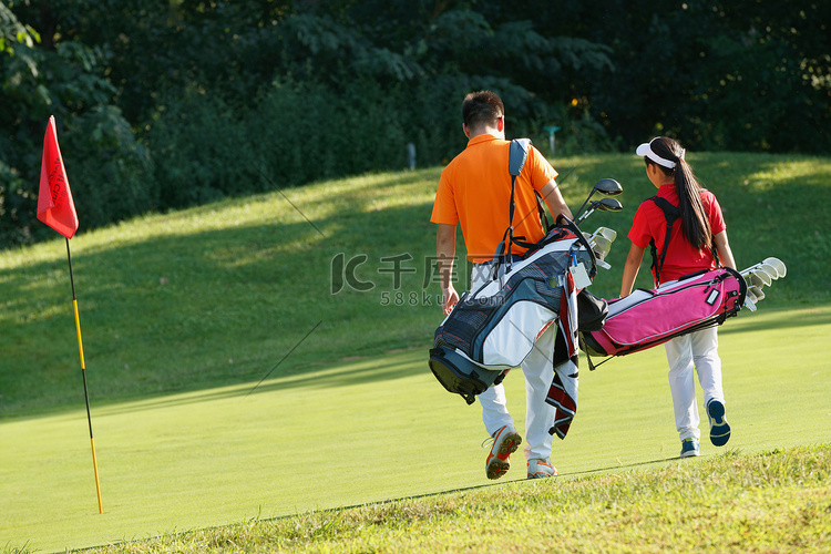 球场上教练和学生背着高尔夫球包