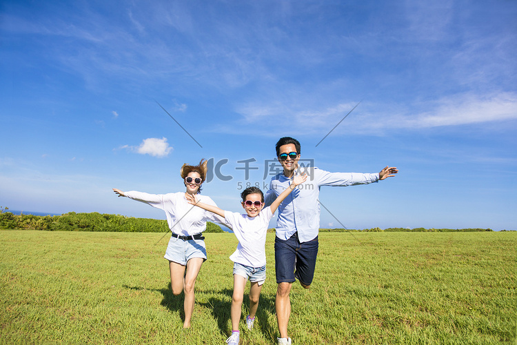 幸福的家庭一起在草地上奔跑