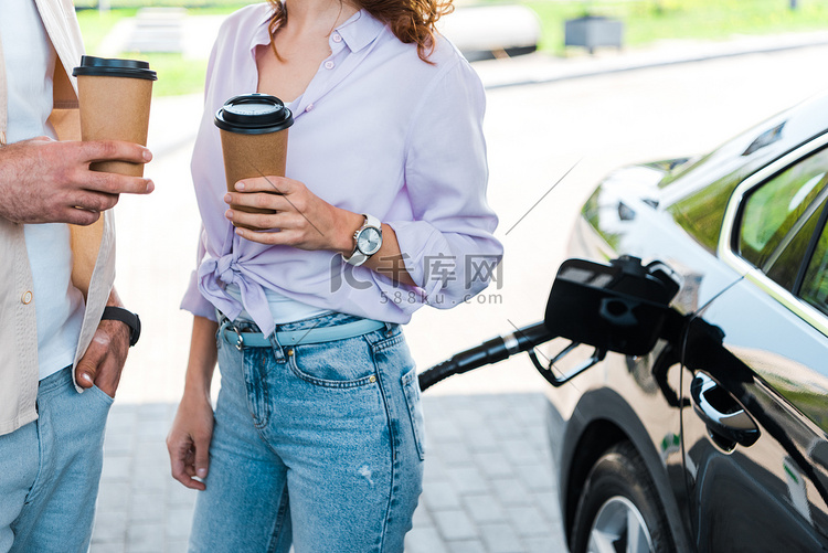 在加油站拿着纸杯的女人拿着纸杯