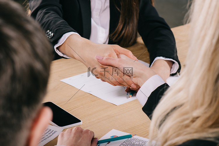 两位女商人在办公室里握手的看法