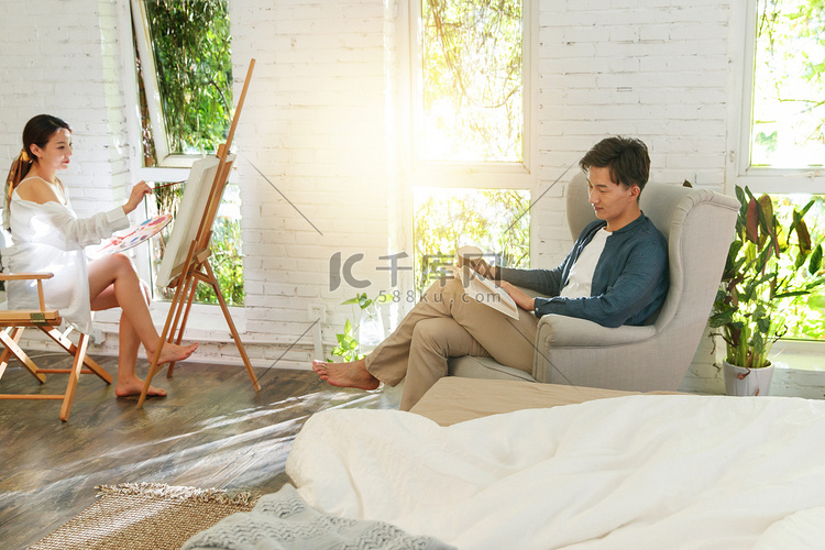 快乐的青年伴侣在家绘画看书