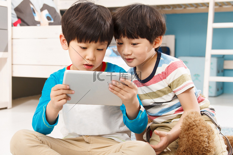 两个男孩在使用平板电脑