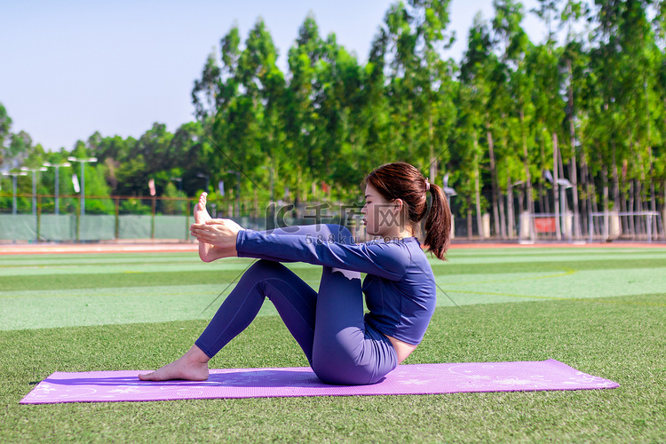 年轻女性在室外操场运动做瑜伽
