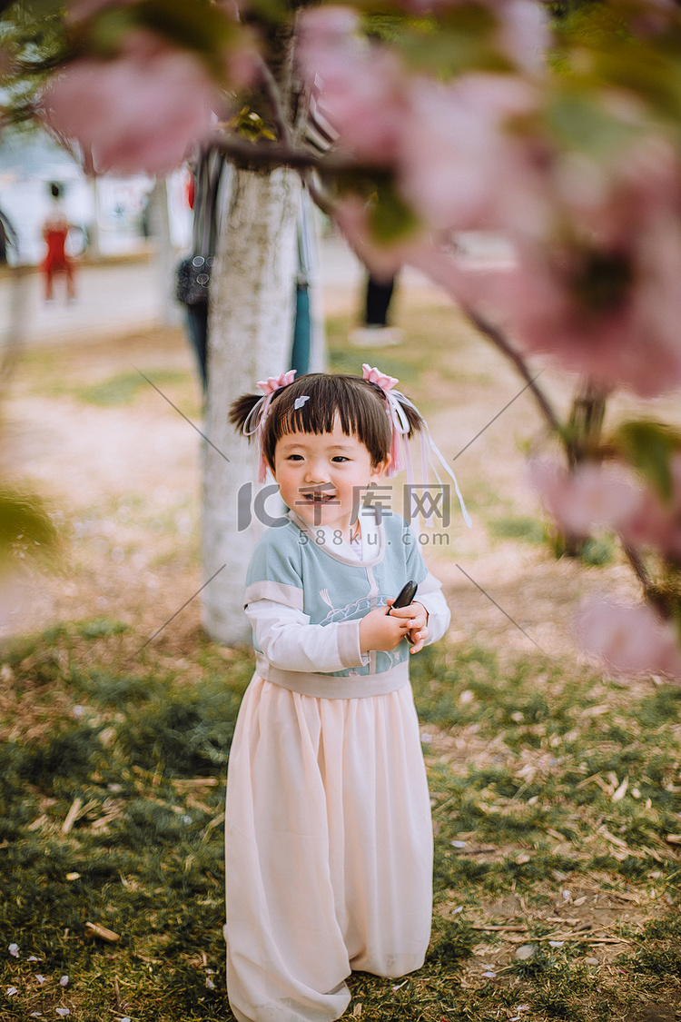 儿童春游白天小女孩户外樱花树捧