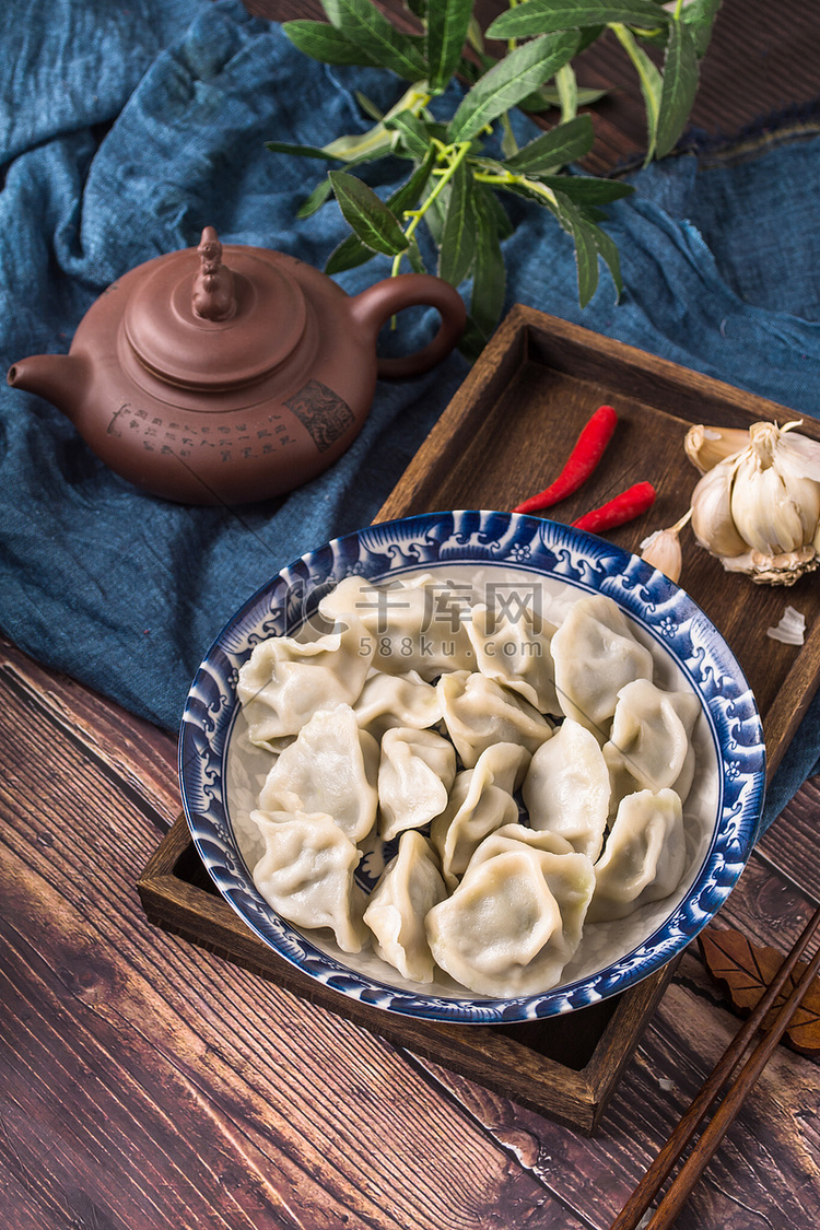 美食木桌水饺大蒜茶壶摄影图