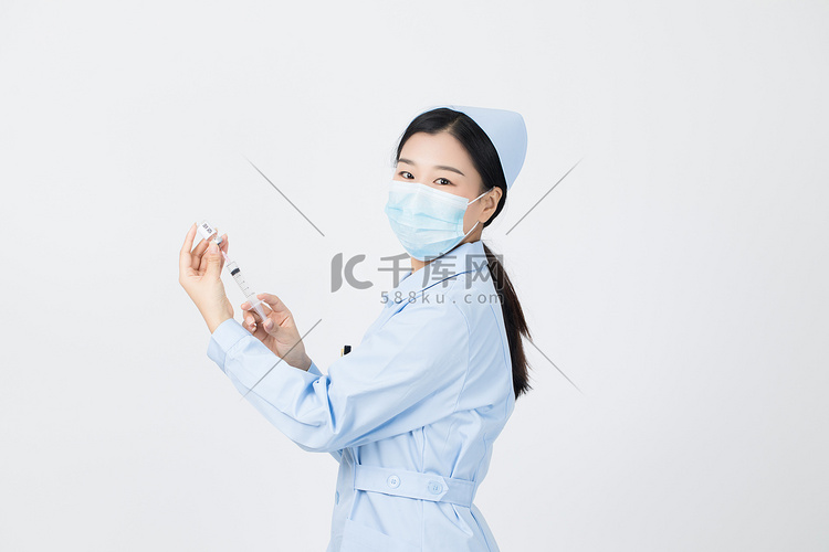 用注射器吸收疫苗药水的护士