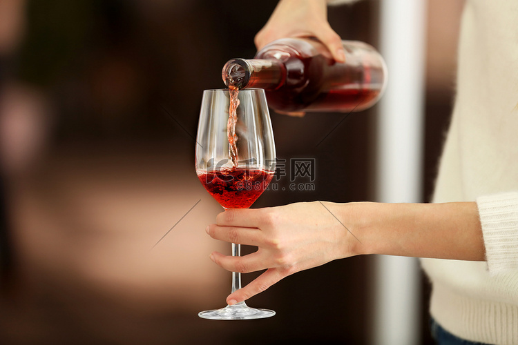 桃红葡萄酒涌入玻璃模糊背景上的