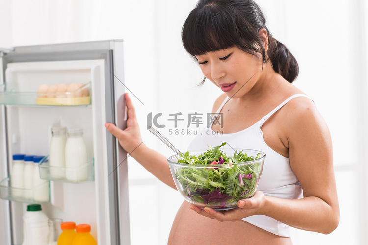 孕妇打开冰箱拿蔬菜