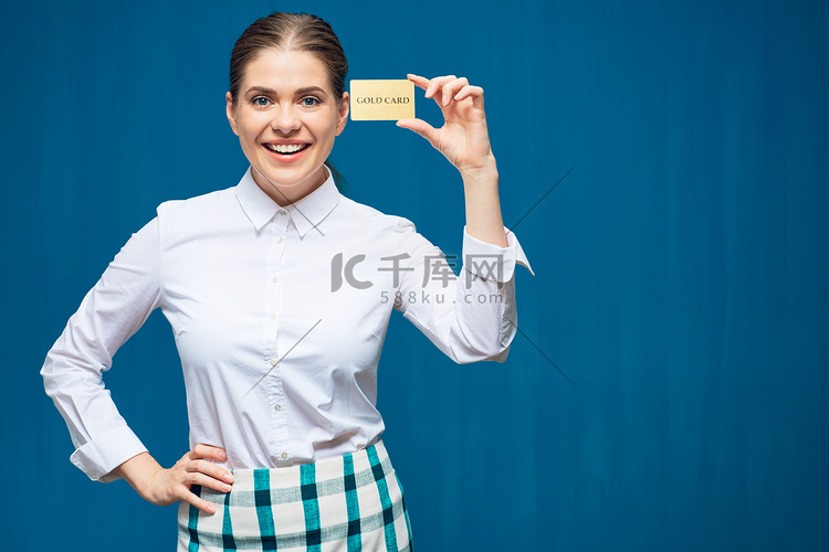 蓝色背景的微笑的妇女持有信用卡