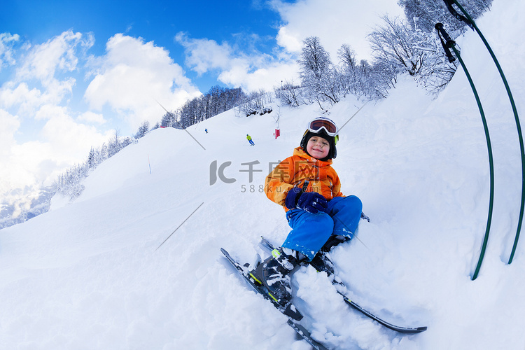 男孩坐着雪橇在雪休息